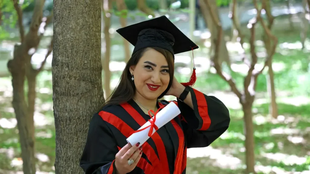 Jeune diplômée souriante en toge avec son diplôme