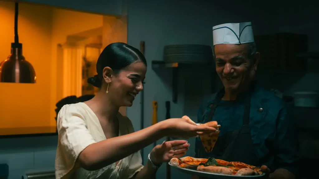 Serveuse qui prend une assiette tendue par le cuisinier