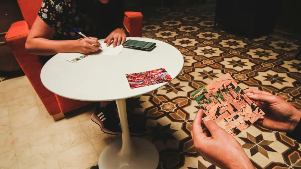 Personne qui écrit à la main sur une petite table ronde