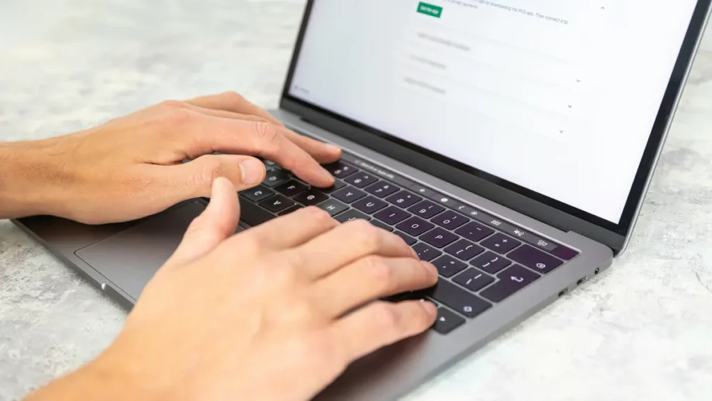 Mains qui tapent sur le clavier d'un ordinateur portable