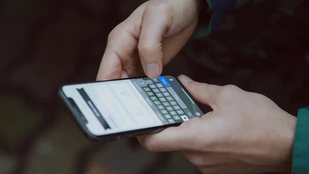 Mains qui écrivent un message sur un smartphone