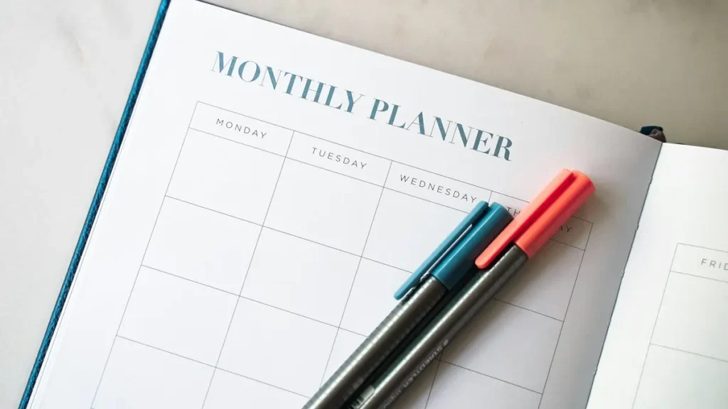 Agenda mensuel ouvert avec deux stylos