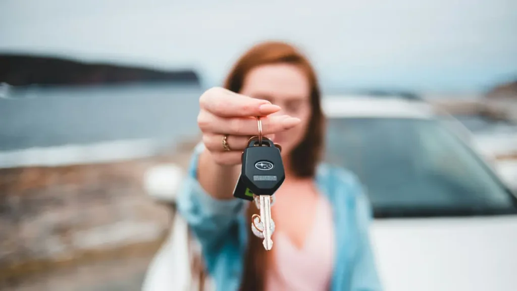 Jeune femme tendant des clés de voiture