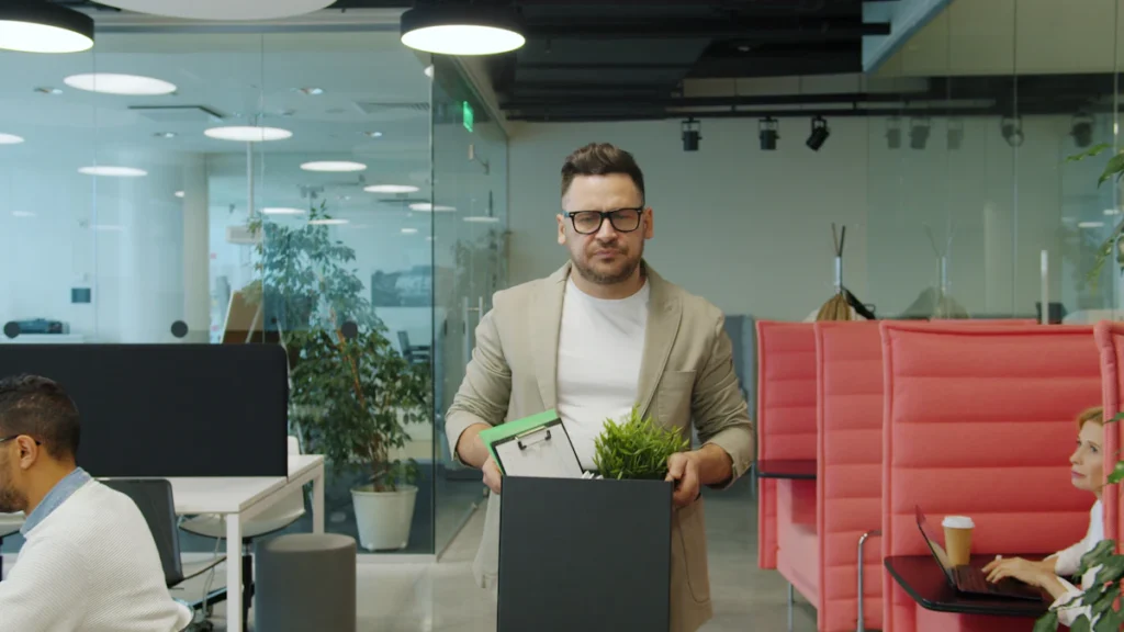 Homme qui range ses affaires dans un carton au bureau