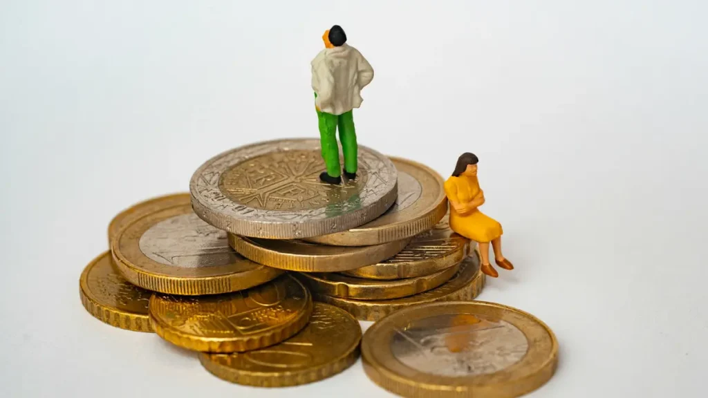 Figurines miniatures sur une pile de pièces de monnaie