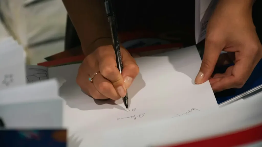 Main qui signe un document avec un stylo