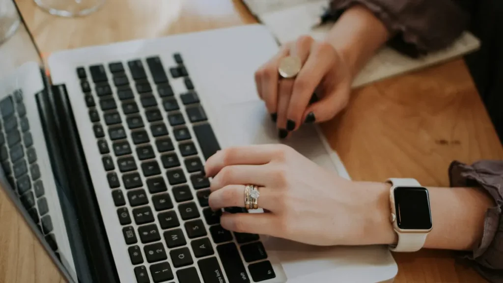 Mains qui tapent sur le clavier d'un ordinateur portable