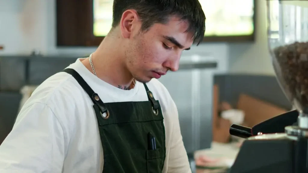 Jeune barista qui prépare un café