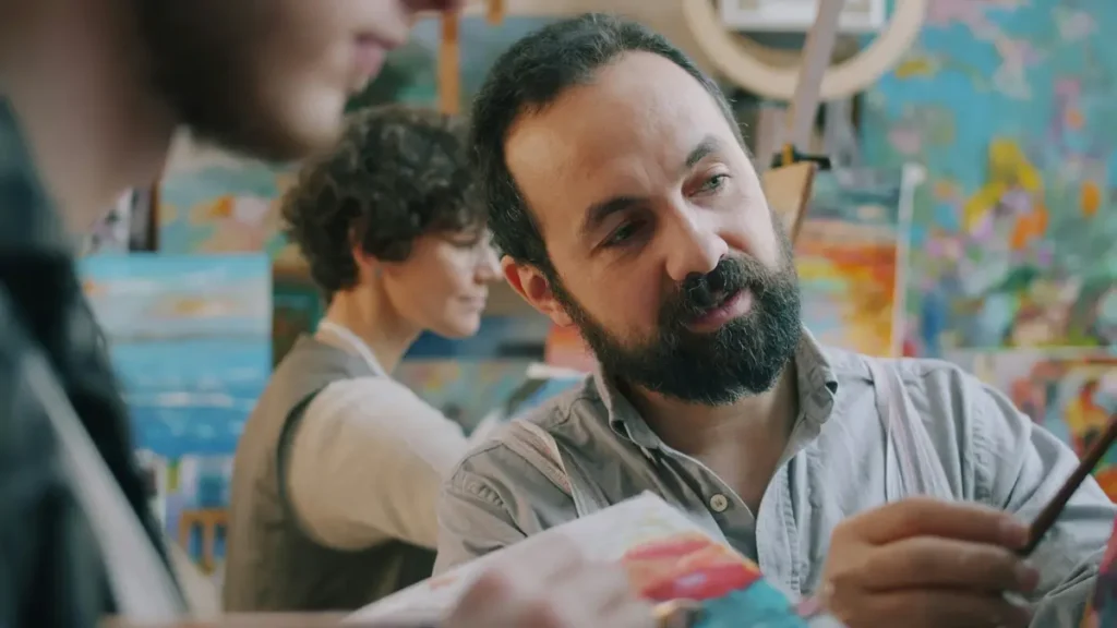 Tuteur qui conseille une jeune femme dans un atelier