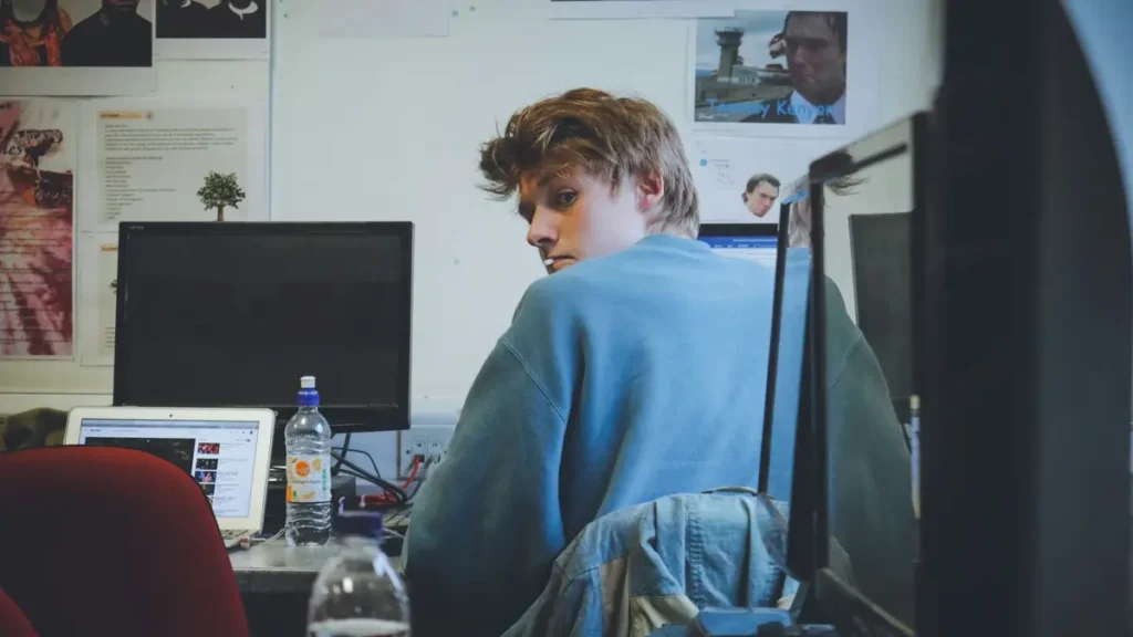 Jeune homme assis devant un ordinateur dans un bureau