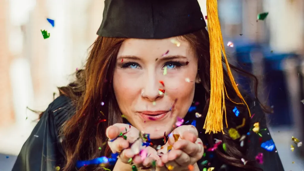 Femme diplômée qui souffle des confettis